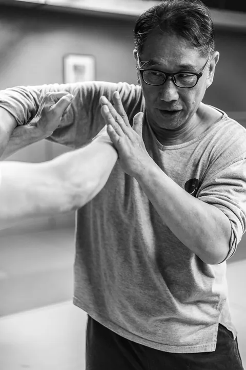 Maître Luo Dexiu en garde, avant-bras levés.